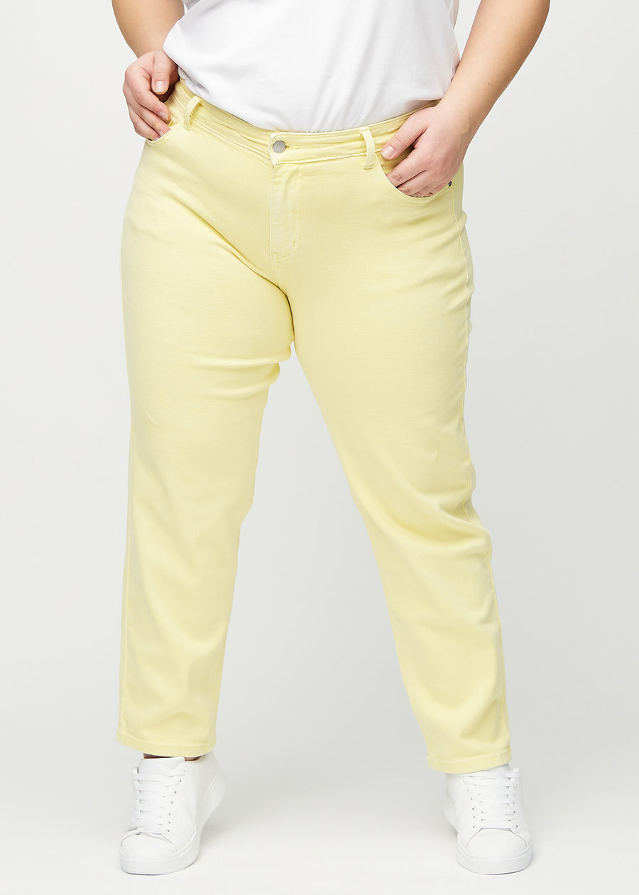 Light yellow regular jeans, model name Lemonades, which go straight down the leg on a plus-size model, seen from the front.