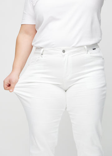 Regular jeans for women in white, color Marguerites. A plus-size model stretches the fabric at the thigh to show its stretch.