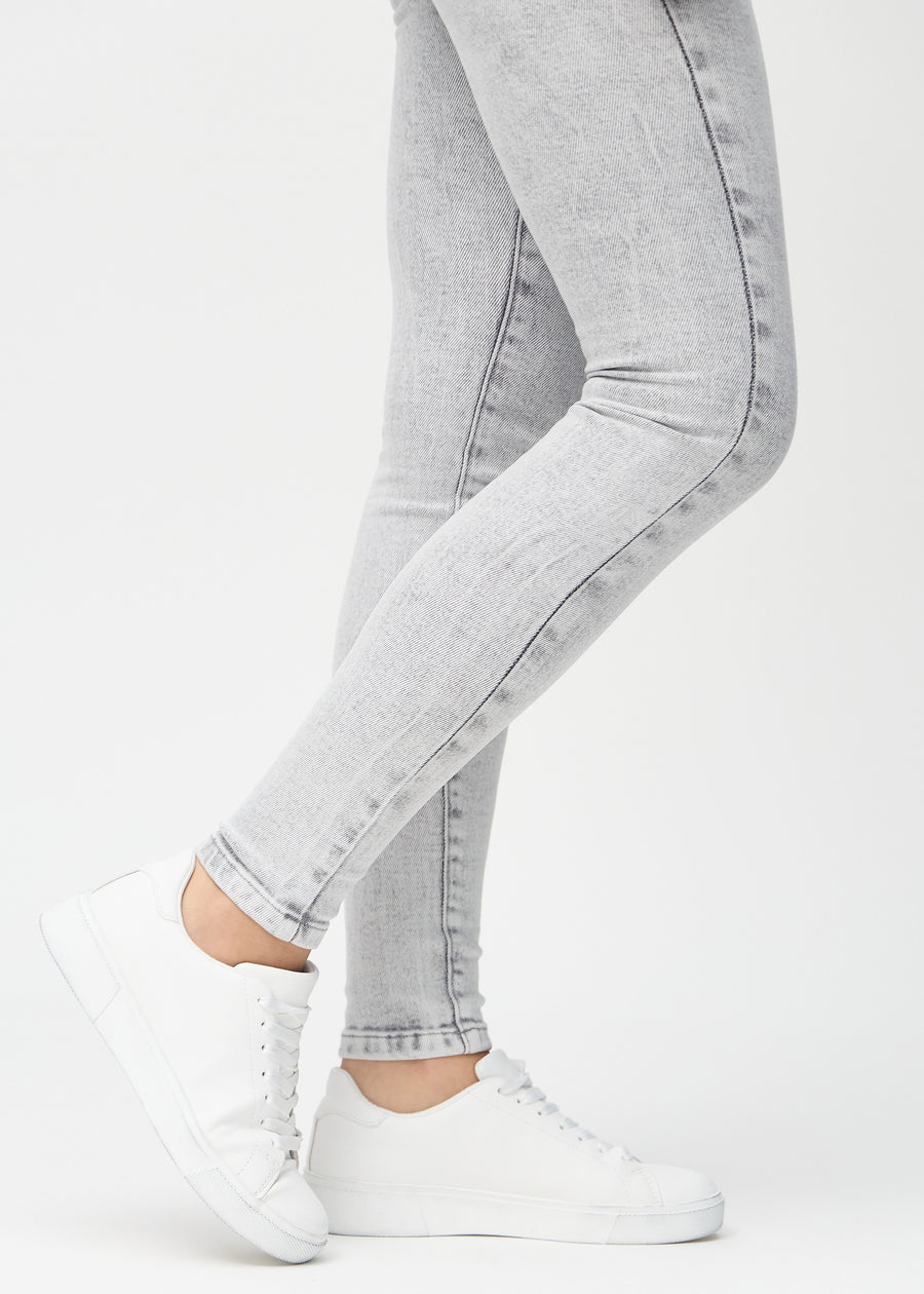 Skinny jeans for women in light grey, color Ashes. Close-up of the snug-fitting leg openings at the ankles on a model.