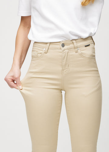 The model stretches the jeans at the thigh to show the stretch.