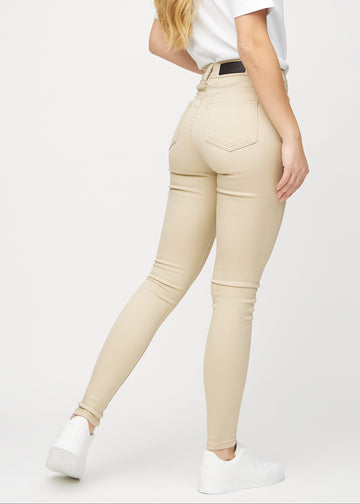 Beige skinny jeans seen from the back, so the full product can be seen.