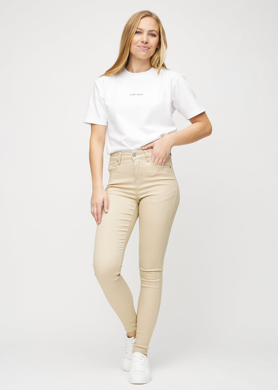 Full image of model in beige skinny jeans.