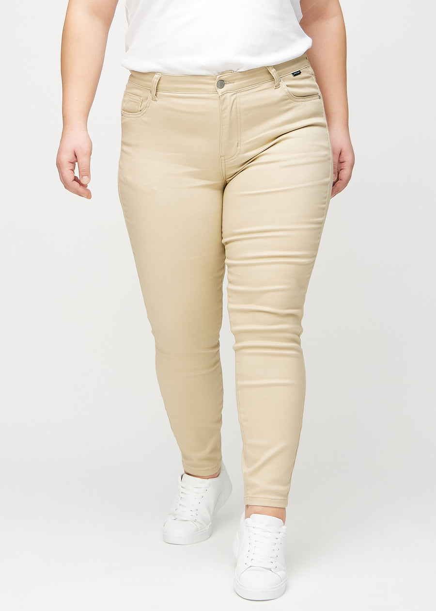 Beige skinny jeans, model name Gazelles, which fits closely to the leg on a plus-size model, seen from the front.
