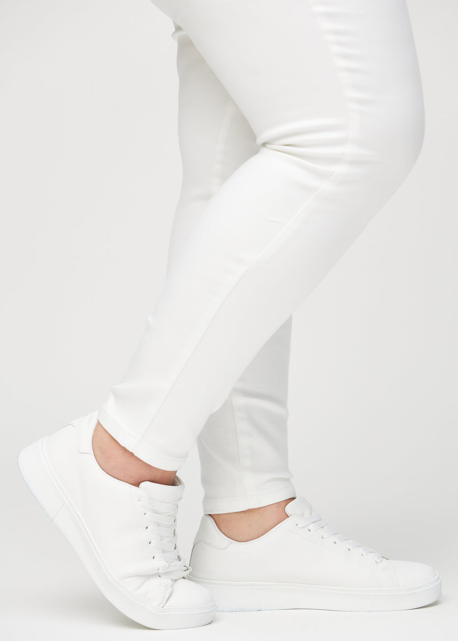 The ankles of a plus-size model, so you can see how tightly the jeans fit.