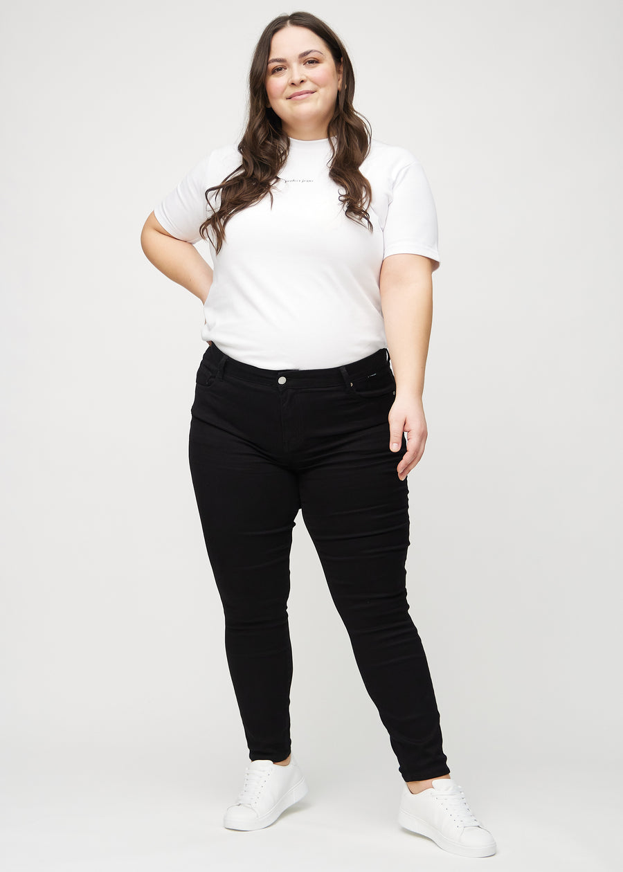 Full image of a plus-size model in black skinny jeans.
