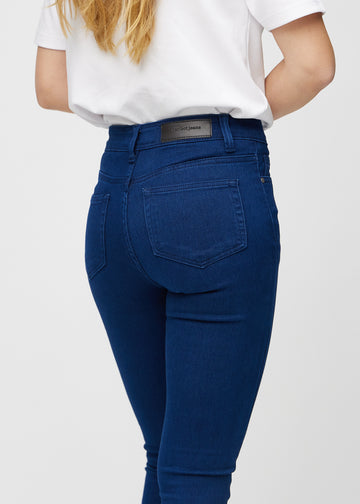 Dark blue skinny jeans viewed from the back close up to show details.