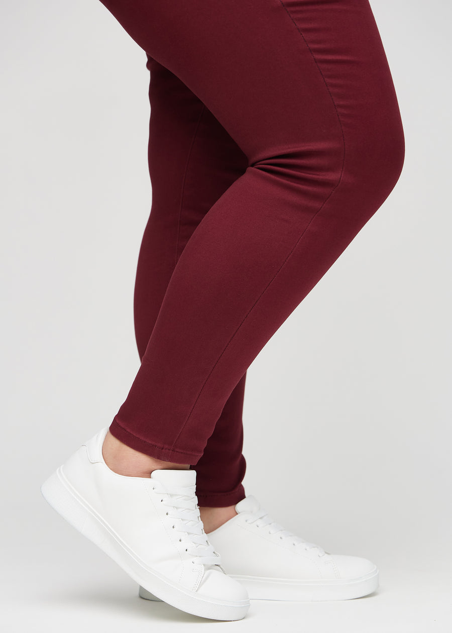 The ankles of a plus-size model, so you can see how tightly the jeans fit.