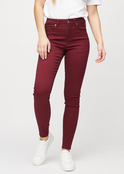 Dark red skinny jeans, model name Santas, which fit closely to the leg, seen from the front.