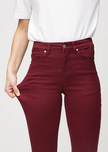 The model stretches the jeans at the thigh to show the stretch.