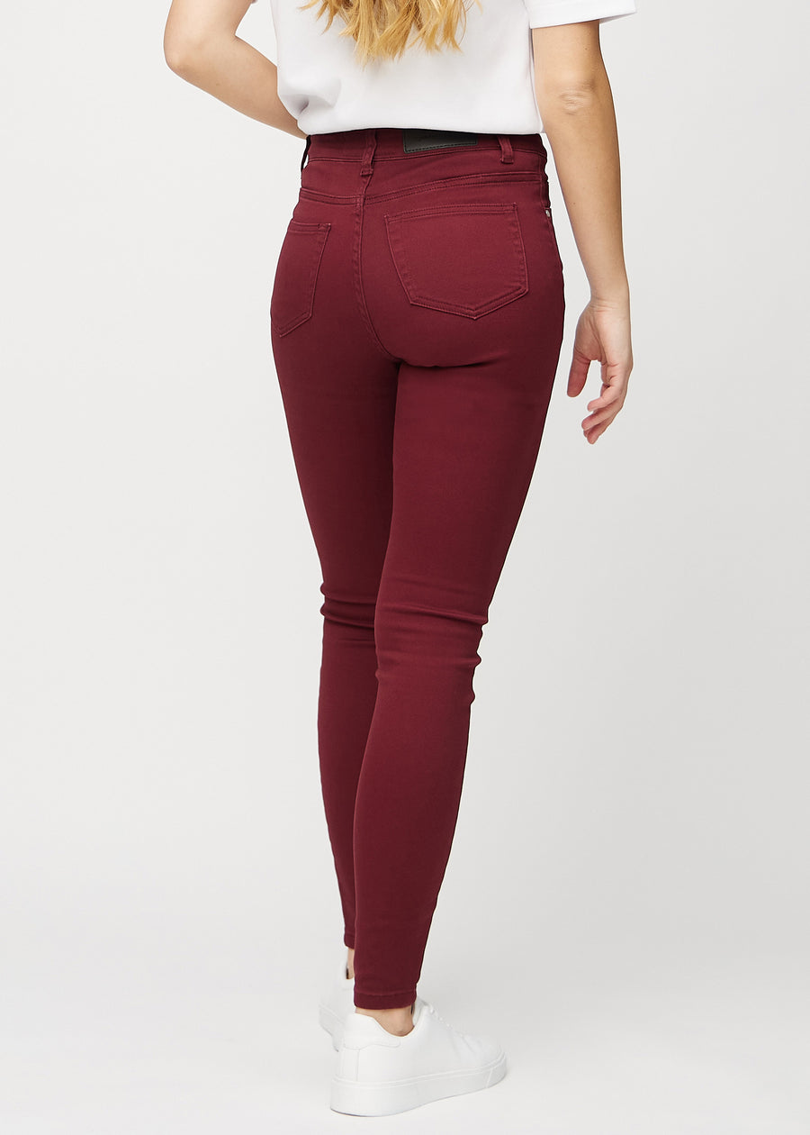 Dark red skinny jeans seen from the back, so the entire product can be seen.