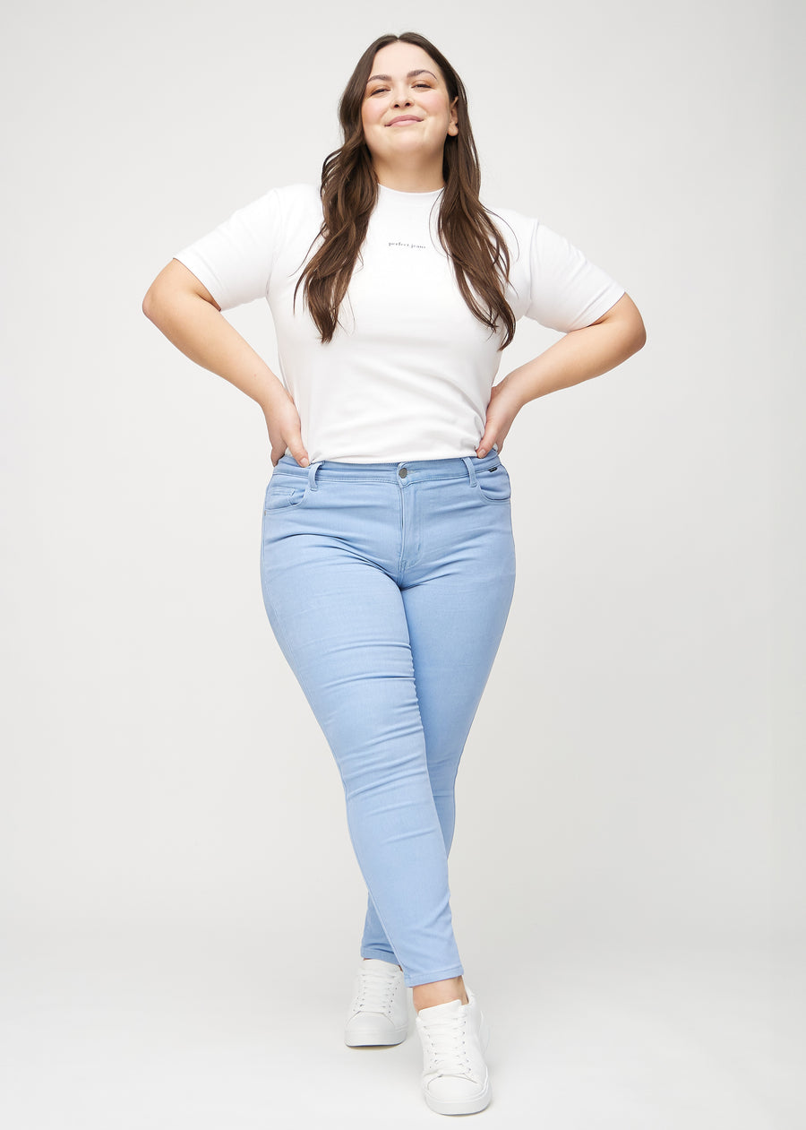 Skinny jeans for women in light blue, color Skies. Full-length view of a plus-size model wearing the jeans.