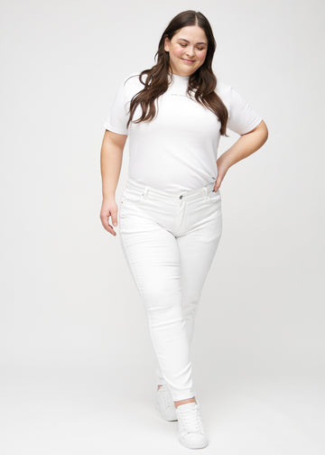 Slim jeans for women in white, color Marguerites. Full-length view of a plus-size model wearing the jeans.