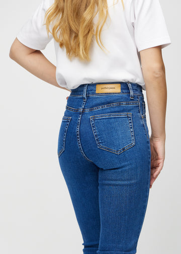 Slim jeans for women in dark blue, color Oceans. Close-up back view on a model, showing the details.