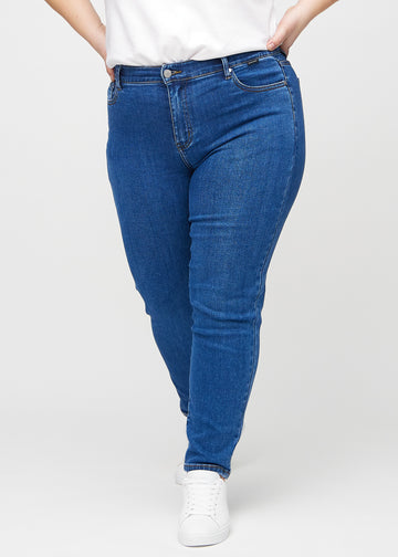 Slim jeans for women in dark blue, color Oceans. Front view on a plus-size model, showing a close fit through the leg with a little more room at the ankle.