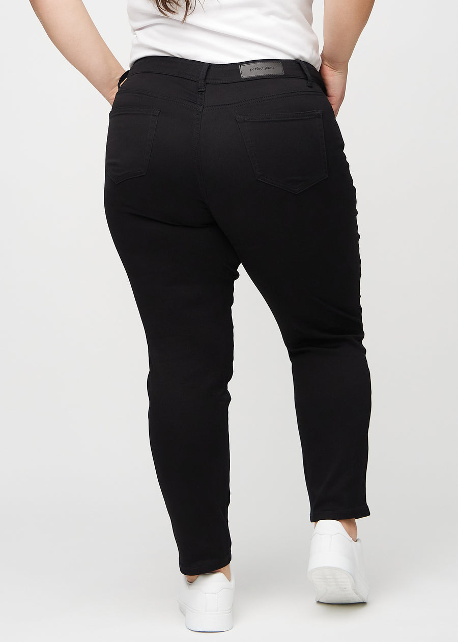 Slim jeans for women in black, color Ravens. Back view on a plus-size model, showing the overall fit.