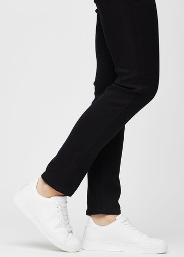 Slim jeans for women in black, color Ravens. Close-up at the ankles on a model, showing the fit at the leg openings.