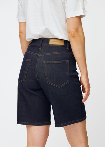 Deep dark blue denim shorts for women in the colour Midnights seen from the back in close-up to show fit and details.
