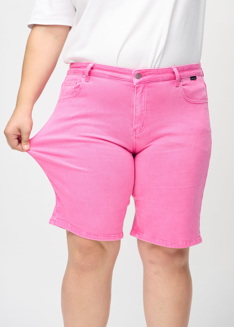 The plus-size model stretches the shorts at the thigh to show the stretch.