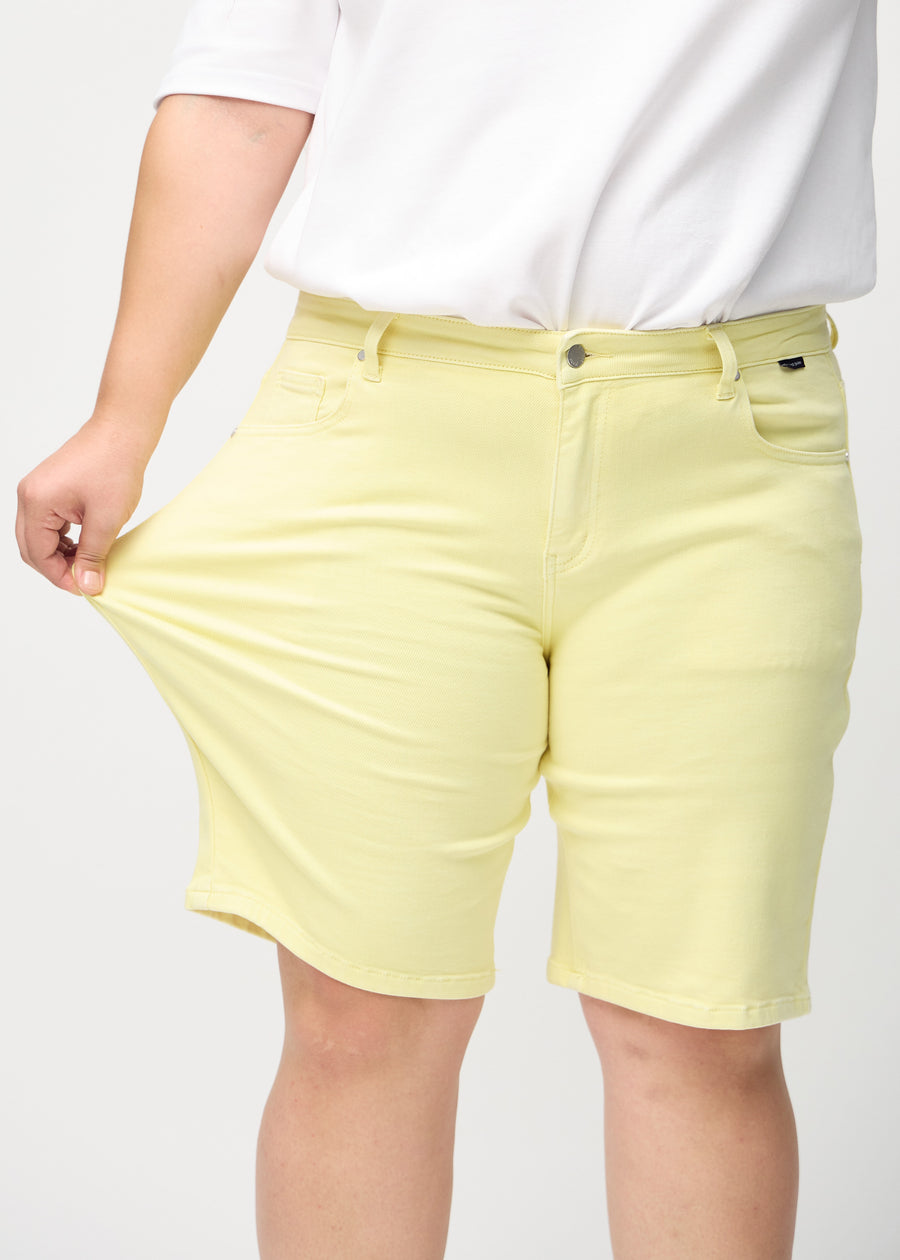 The plus-size model stretches the shorts at the thigh to show the stretch.