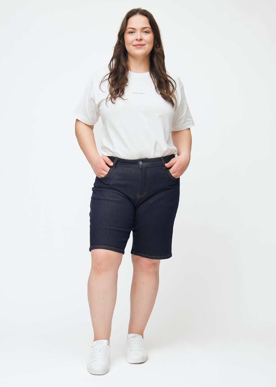 Full image of a plus-size model wearing deep dark blue denim shorts for women in the colour Midnights with a regular fit.