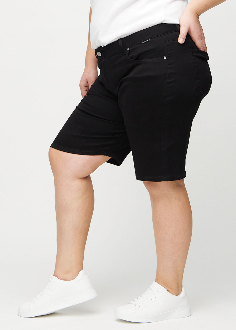 Black regular middle shorts seen from the side on a plus-size model.