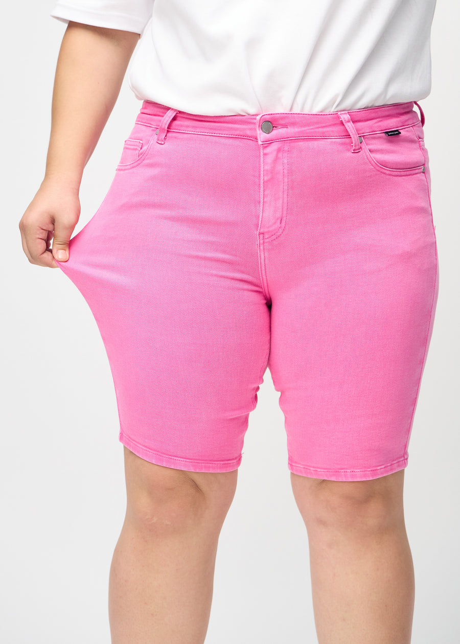 The plus-size model stretches the shorts at the thigh to show the stretch.