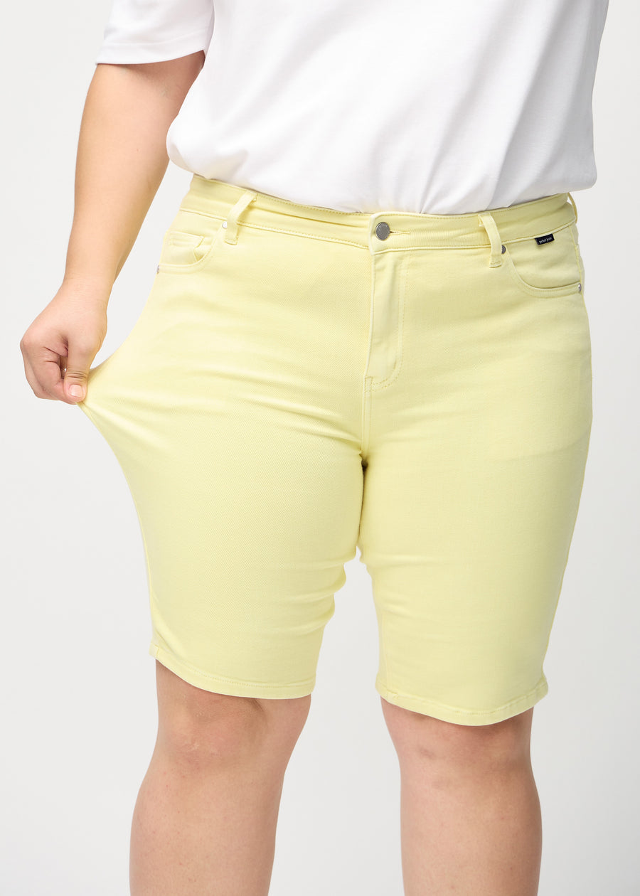 The plus-size model stretches the shorts at the thigh to show the stretch.