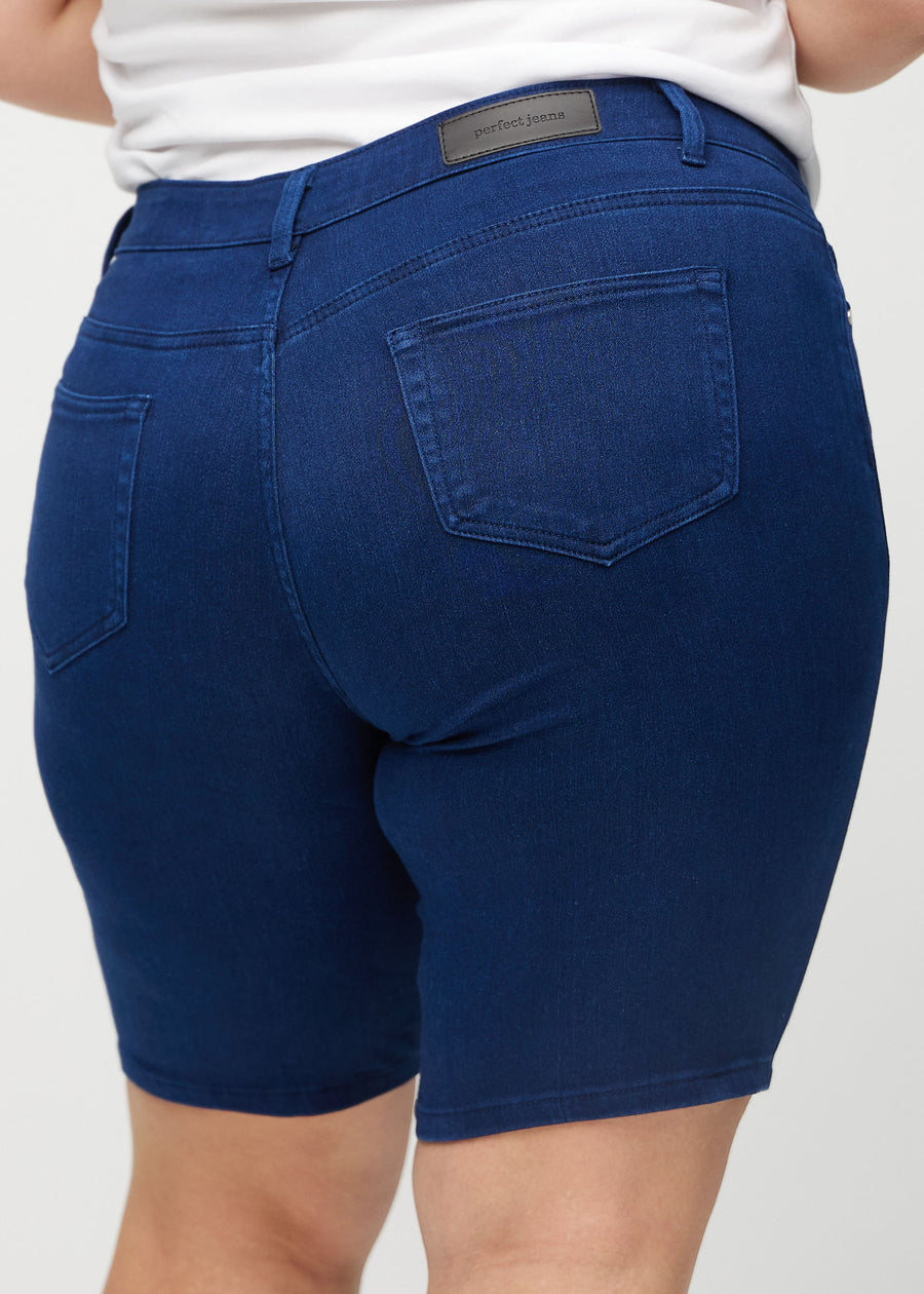 Dark blue skinny middle shorts seen from the back close up on a plus-size model to show details.