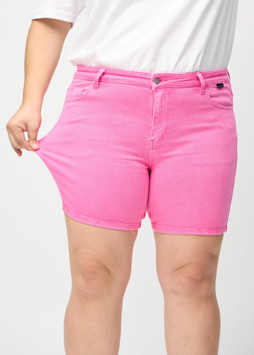 The plus-size model stretches the shorts at the thigh to show the stretch.