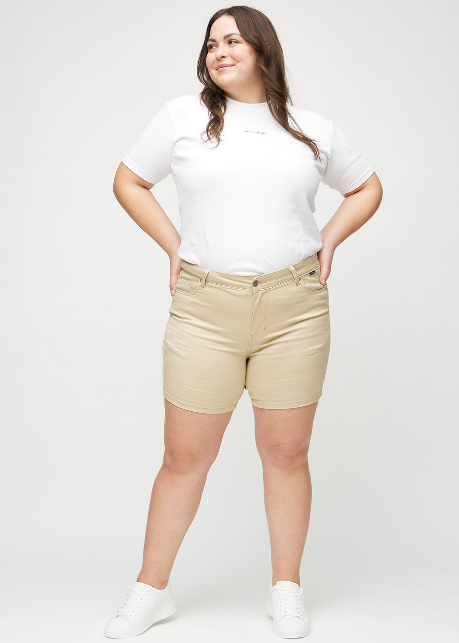 Full image of a plus-size model in beige skinny short shorts.
