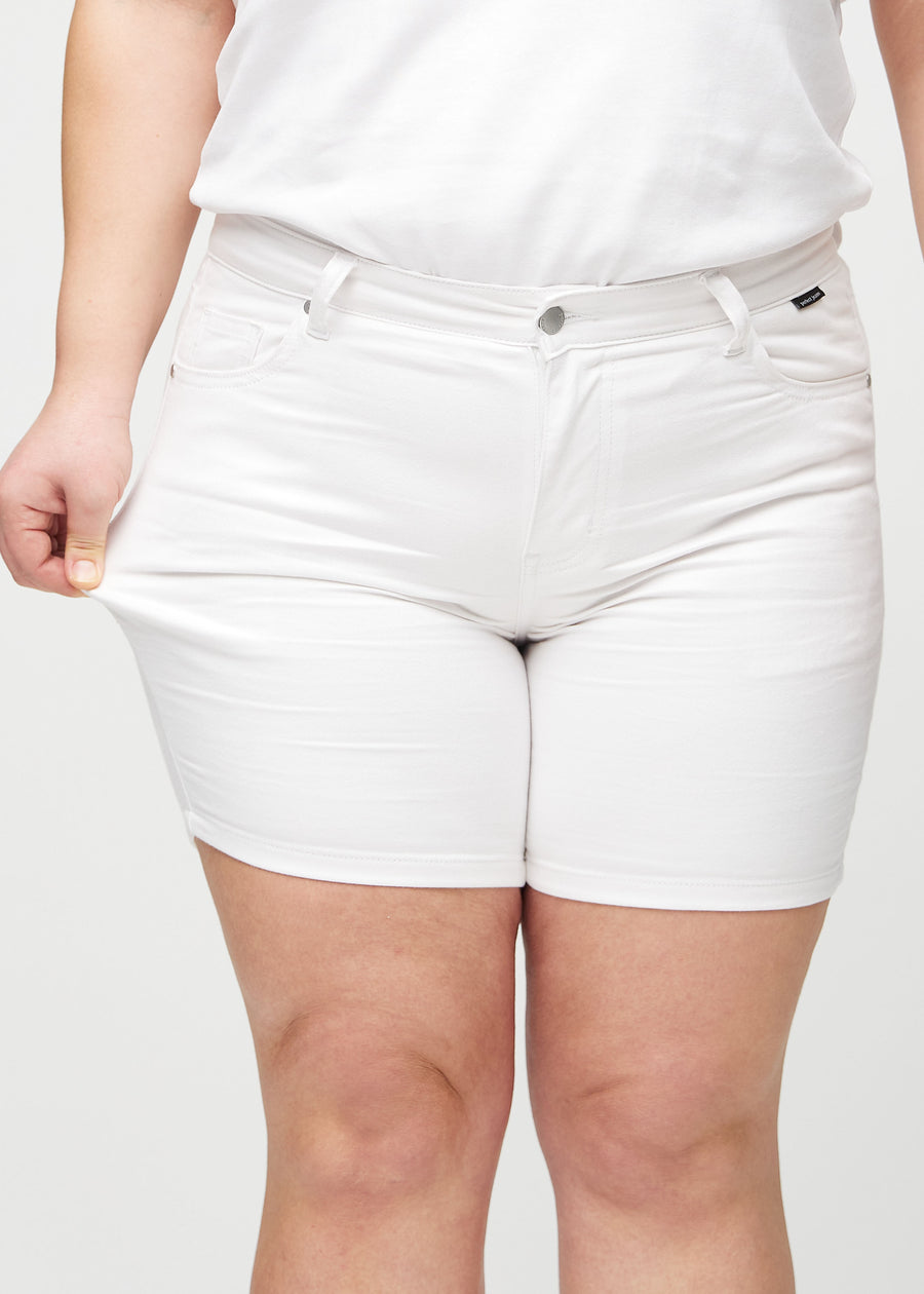 The plus-size model stretches the shorts at the thigh to show the stretch.