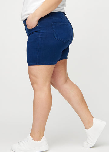 Dark blue skinny short shorts seen from the side on a plus-size model.