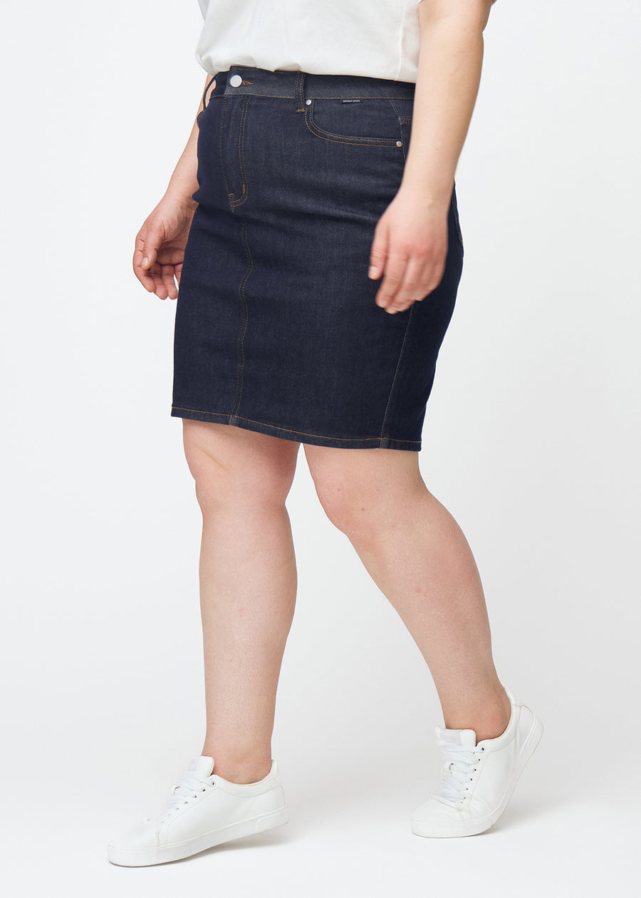 Deep dark blue denim skirt for women in the colour Midnights seen from the side on a plus-size model.