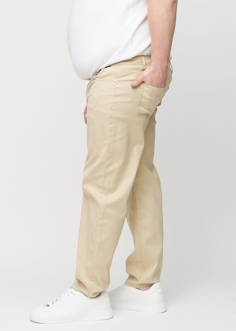 Beige regular jeans seen from the side on a plus-size model.