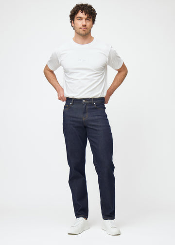 Full image of a model in deep dark blue denim jeans for men in the color Midnights with a regular fit.