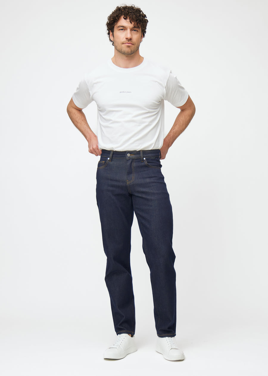 Full image of a model in deep dark blue denim jeans for men in the color Midnights with a regular fit.