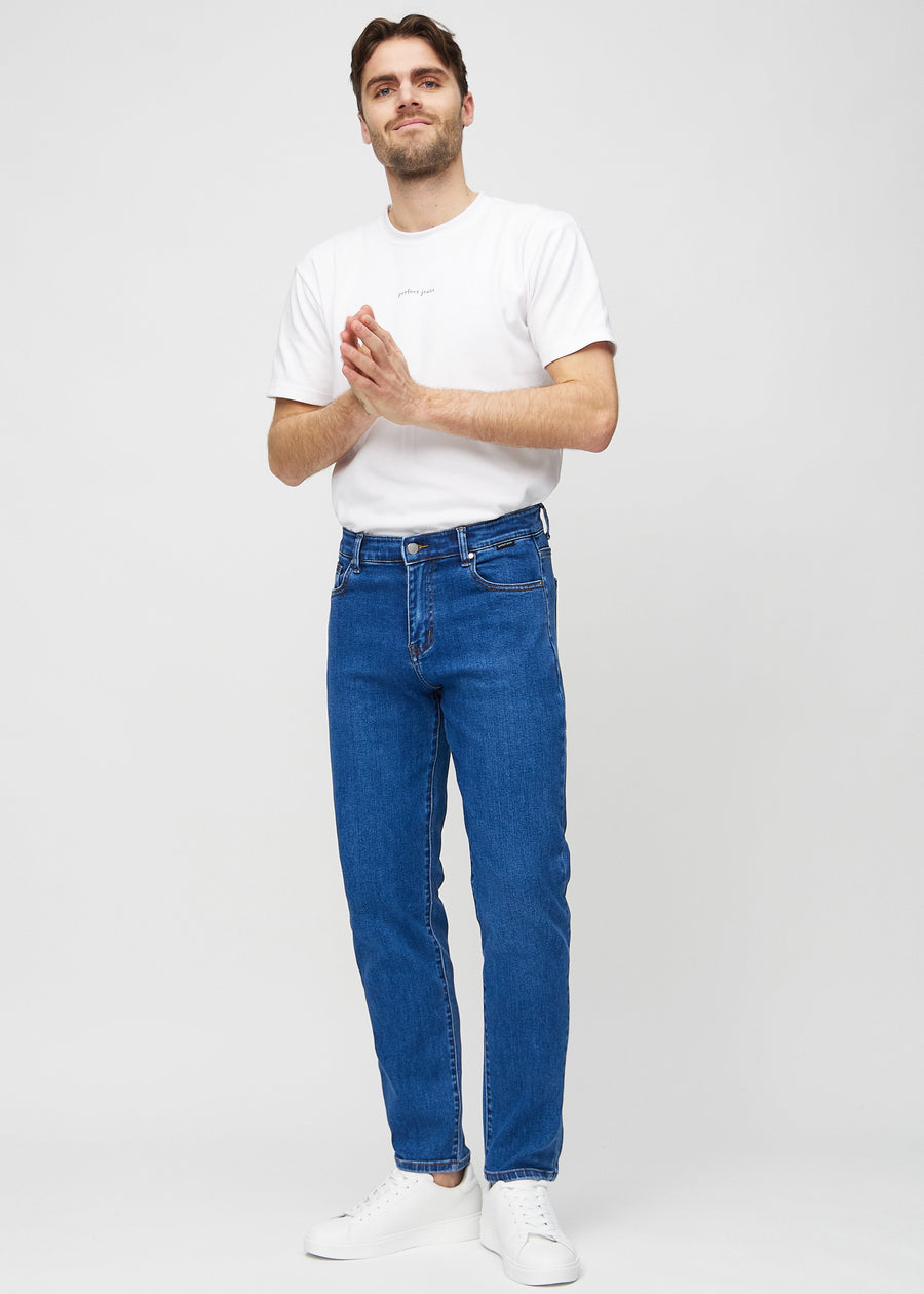 Full image of model in dark blue denim regular jeans.