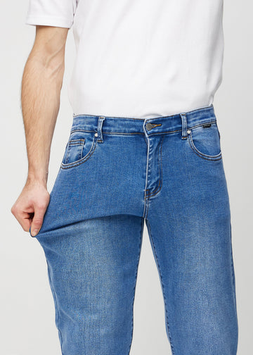 The model stretches the jeans at the thigh to show the stretch.