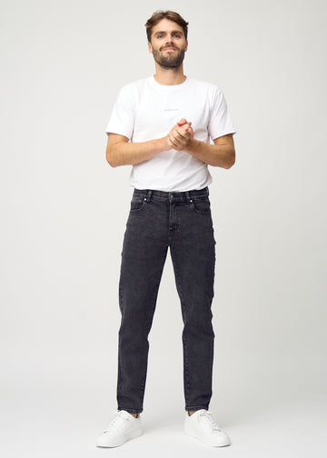 Full image of model in dark grey denim regular jeans.