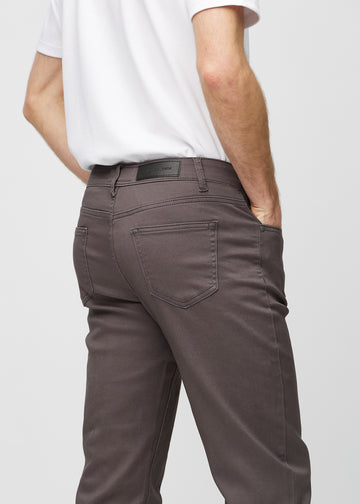 Grey-brown regular jeans seen from the back close up to show details.