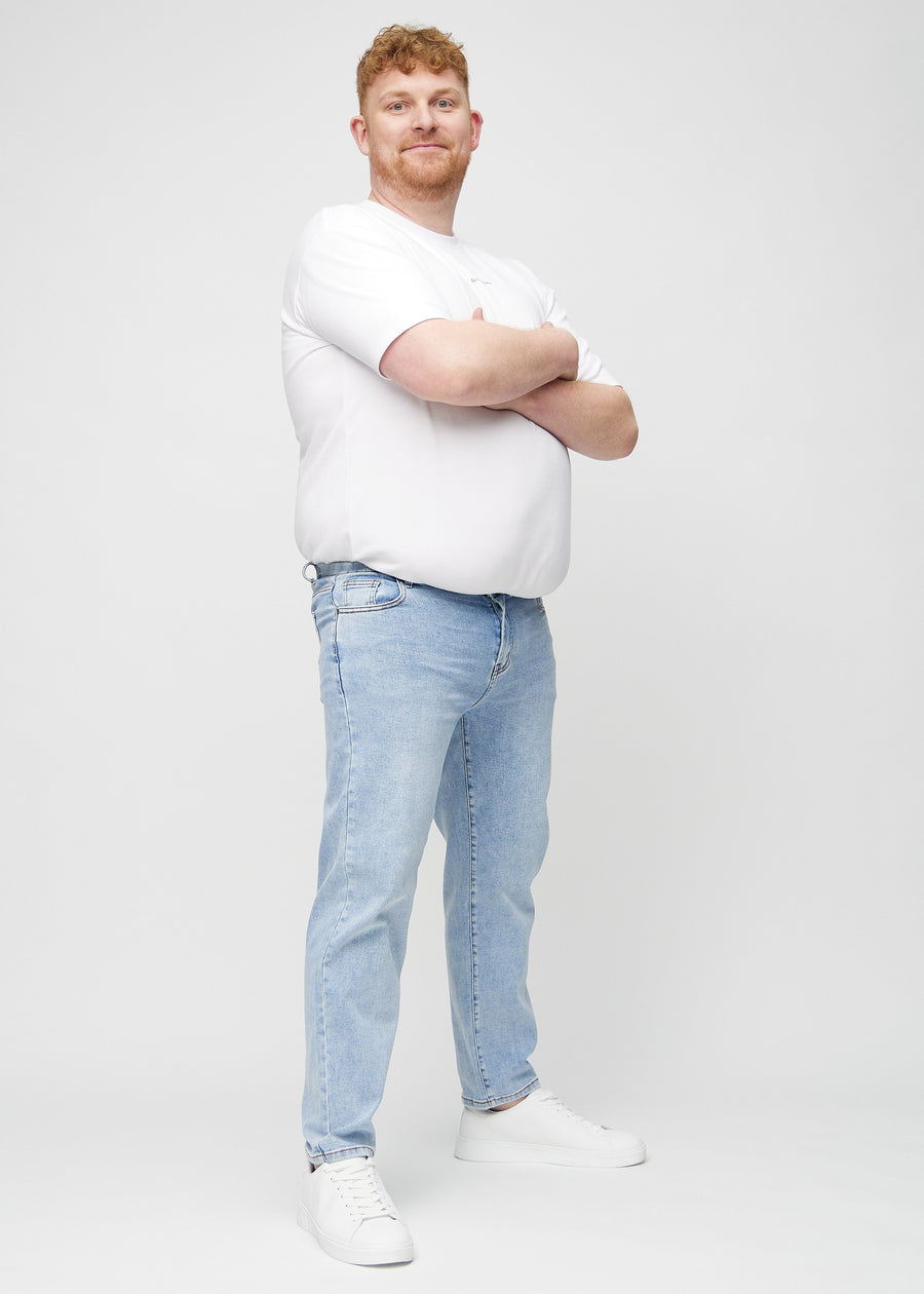 Full image of a plus-size model in light denim regular jeans.