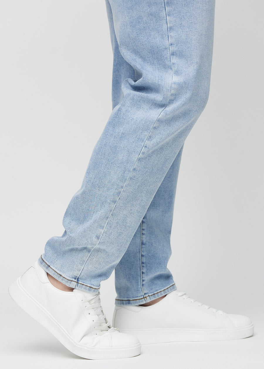 The ankles of a plus-size model, so you can see how loose the jeans fit.