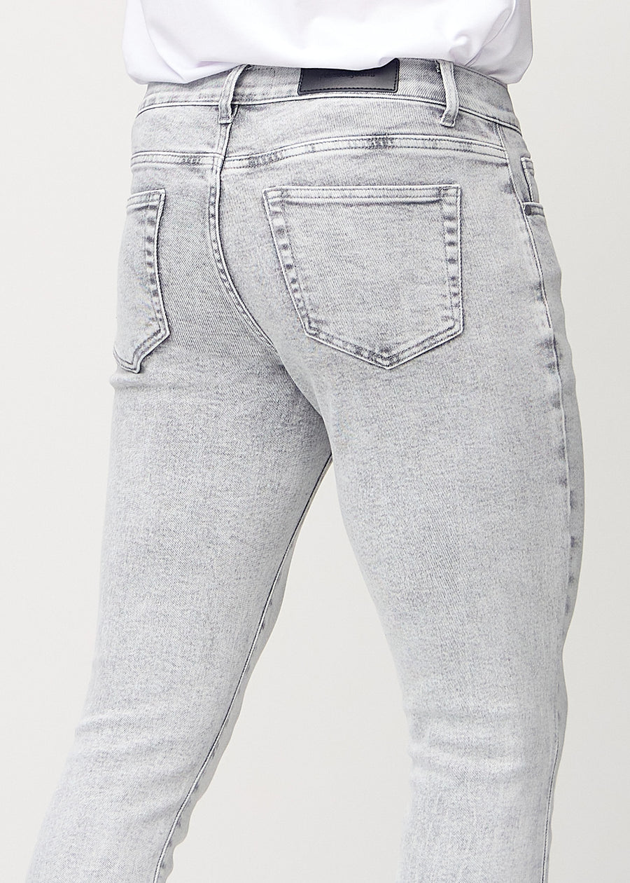 Close-up back view of light grey denim slim jeans showing details.