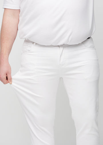 Plus-size model stretches the jeans at the thigh to show the fabric&