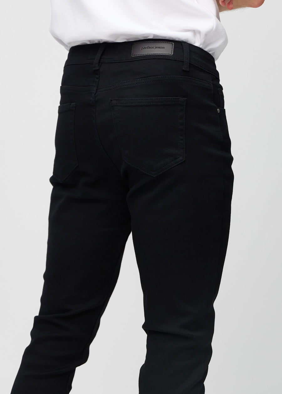 Close-up back view of black slim jeans showing details.