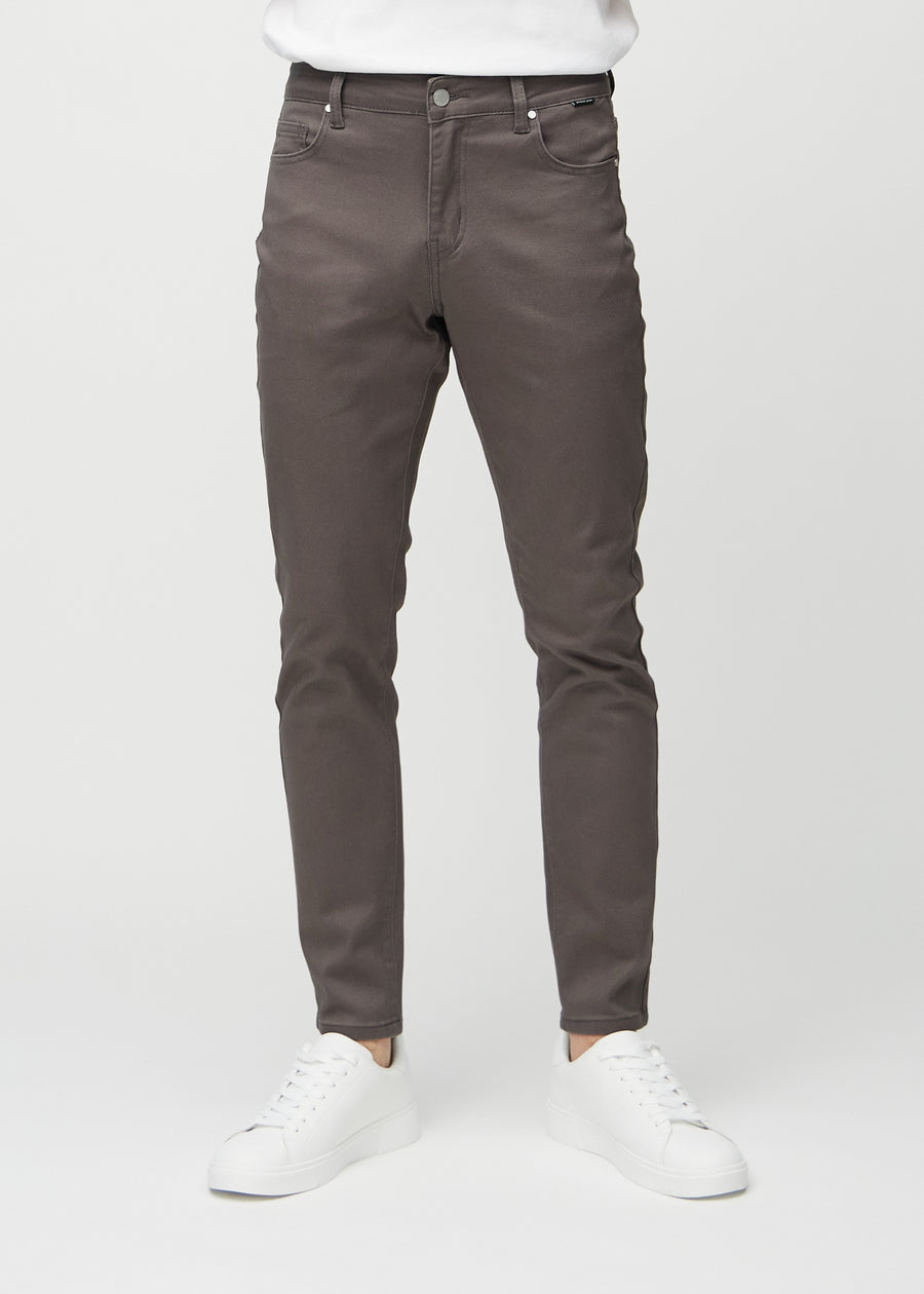 Grey-brown slim jeans, model name Thunders, fitted closely along the legs, front view.