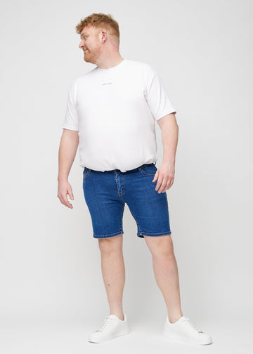 Full image of a plus-size model in dark denim middle-slim shorts.