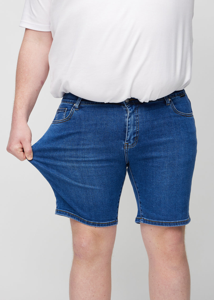 The plus-size model stretches the shorts at the thigh to show the stretch.
