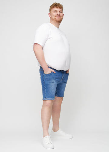 Full image of a plus-size model in denim middle-slim shorts.