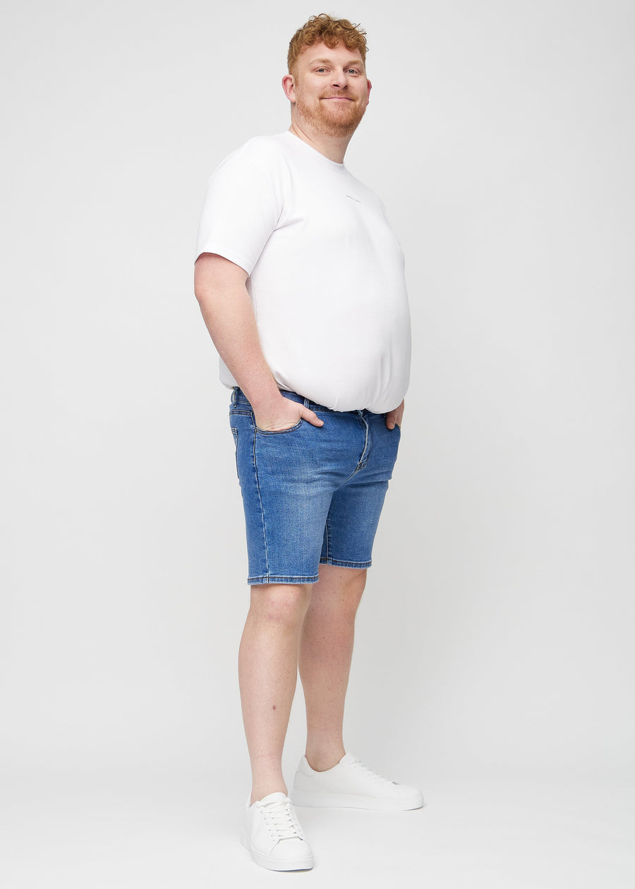 Full image of a plus-size model in denim middle-slim shorts.